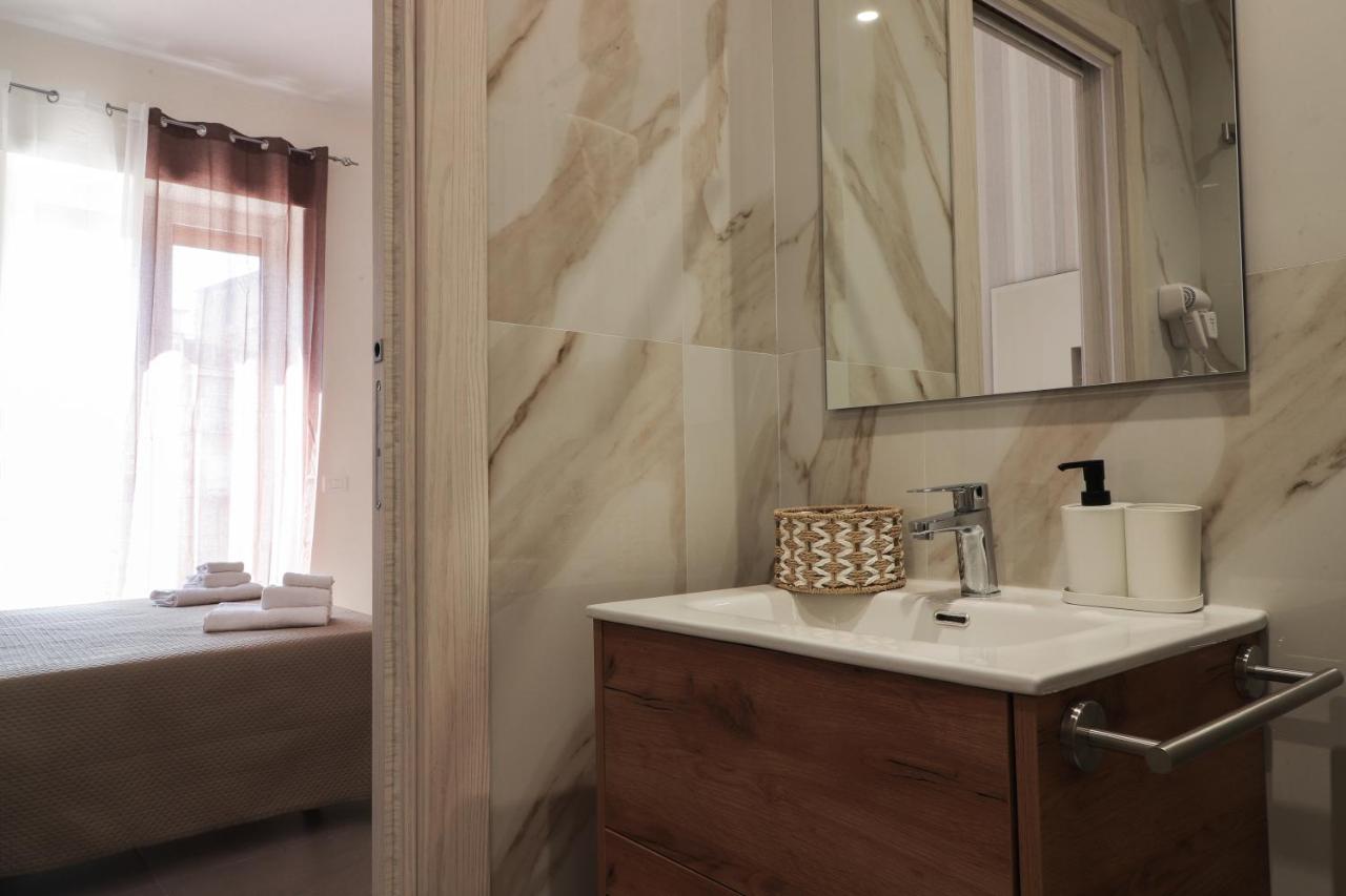 Bagno privato con lavabo in legno e rivestimento effetto marmo